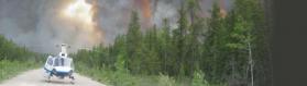 Helicopter on a road in front of a wild-land fire